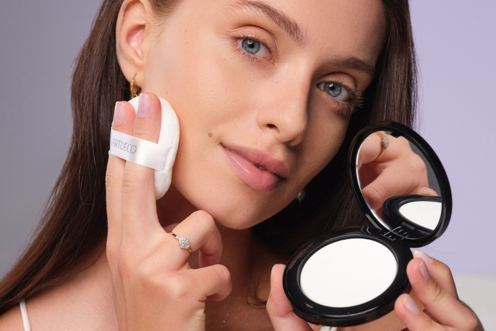 Powder is applied to the face with a powder puff