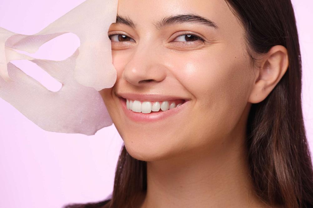 A female person is taking off a facial mask