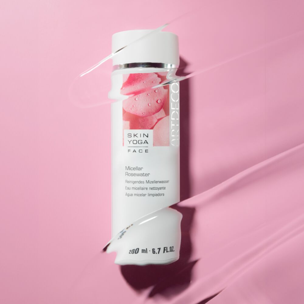 Micellar Rosewater liegt auf einem rosafarbenen Hintergrund