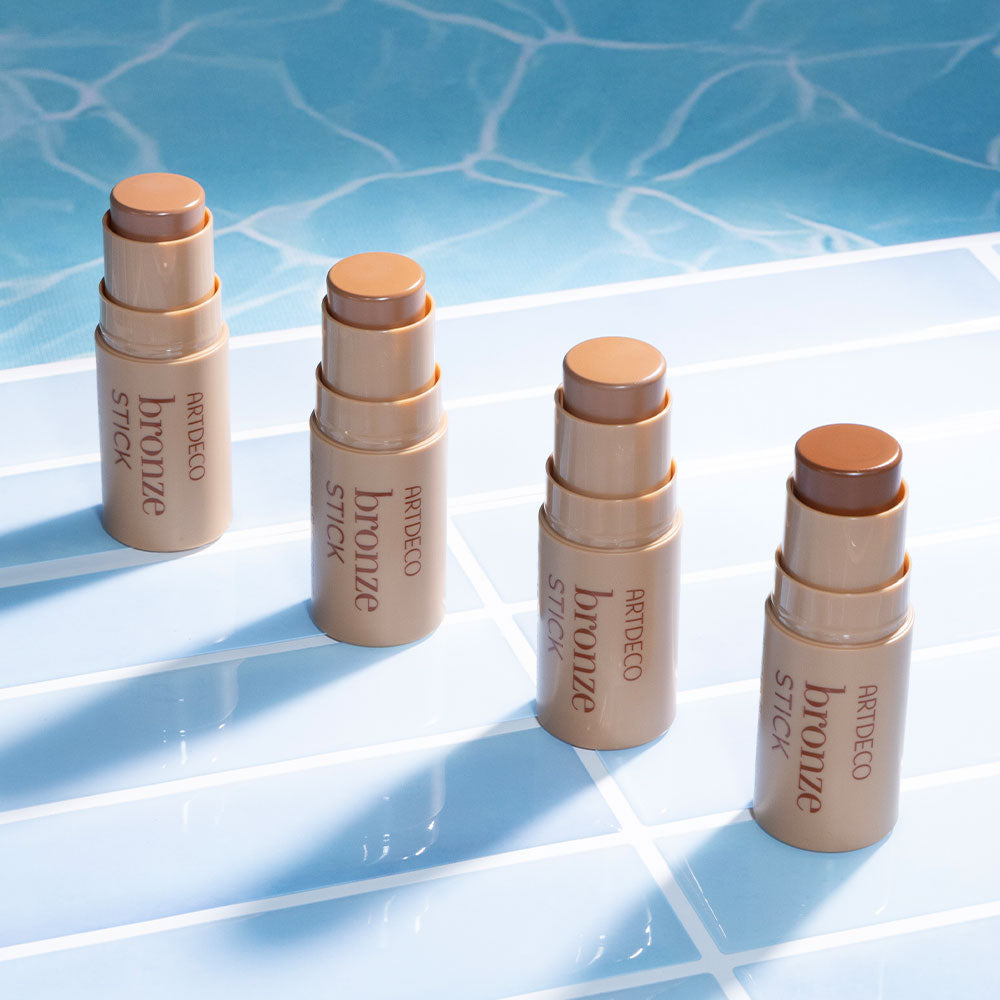 All Artdeco Bronze Stick products at the edge of the pool with waves in the background.