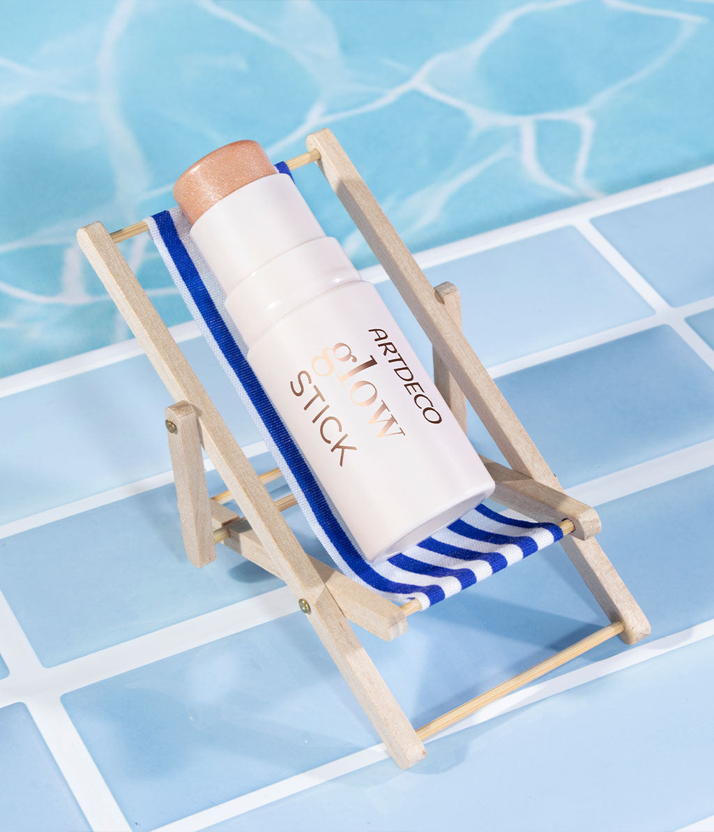 ARTDECO Glow Stick lies in a mini deck chair and is staged as if it were lying by a pool