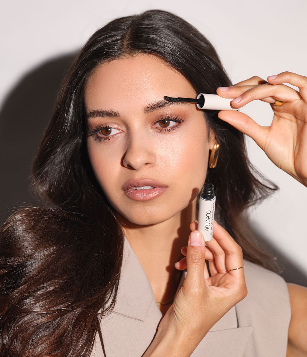 Brown-haired model applies Brow Lift Lamination to her eyebrows and fixes her eyebrows for the whole day