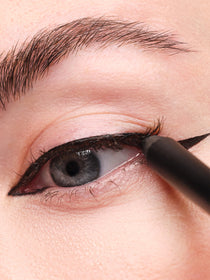Finalize the cat-eye look by thickening the lash line.