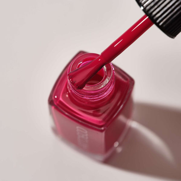 Nail polish bottle of Art Couture Nail Lacquer with soaked brush.