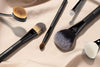 Three different brushes are shown lying on a beige background