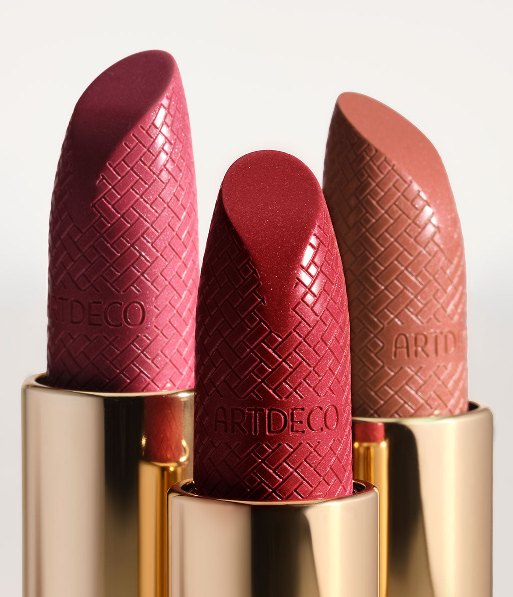 Three open Iconic Lipsticks, with a close-up view of the tip of the lipstick, which features the Intrecciato design and the ARTDECO logo embossed on it.