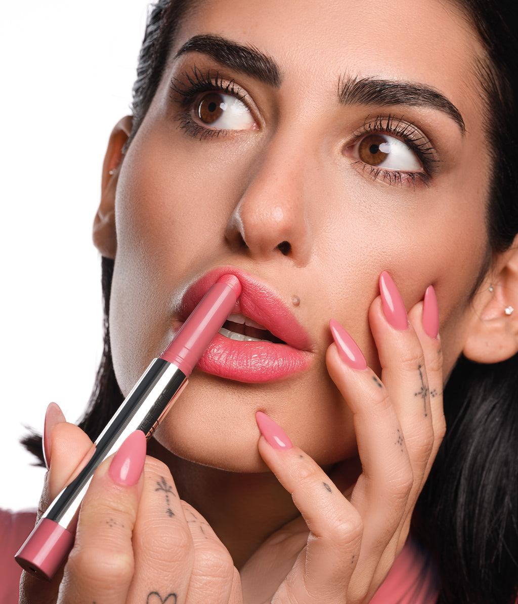 A brunette model applies the Jelly Balm Lipstick in shade N°762 to her lips. Her nails, which match the shade, are also visible.