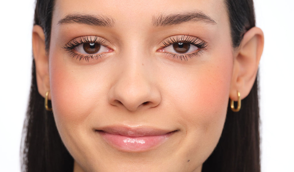 Smiling woman with natural brows before styling – shown as the “before” shot.