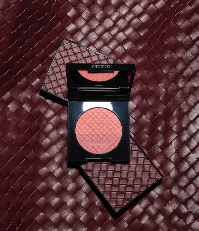 A GIF showing the limited-edition Blush Couture against a background featuring the Intrecciato design. In the GIF, the model applies the blush to her cheeks with her fingers.