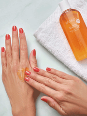 Fingers massage the All in One Manicure into the back of one hand Mousse 