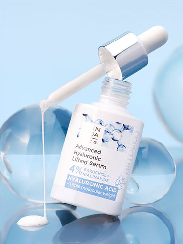 Advanced Hyaluronic Lifting Serum on a light blue background surrounded by different-sized glass beads.  The product drips from the pipette.
