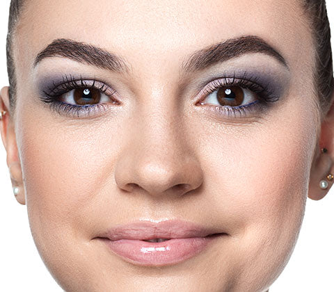 Smiling model wearing makeup looks into the camera.