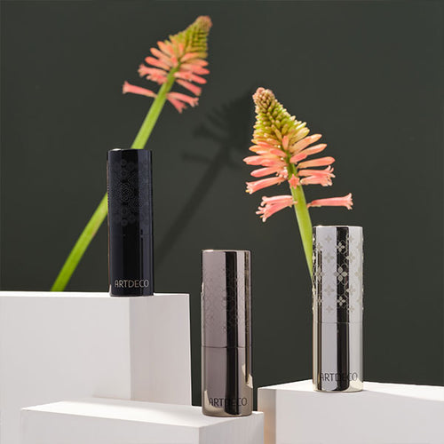 Staging of the three Couture Lipstick Cases on white pedestals with flowers in the background