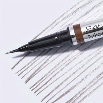 Close-up of the ultra-fine tip of the 24h Micro Brow Liquid Liner with swatches in the background.