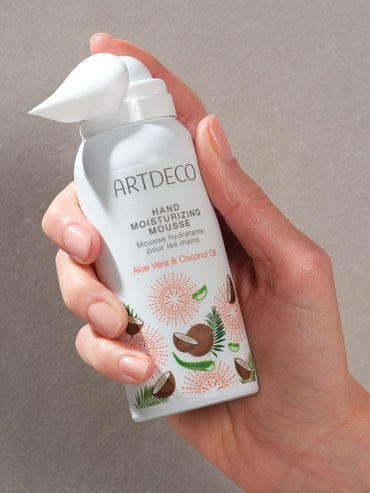 Hand holds limited-edition Hand Moisturizing Mousse and you can see the foamy texture