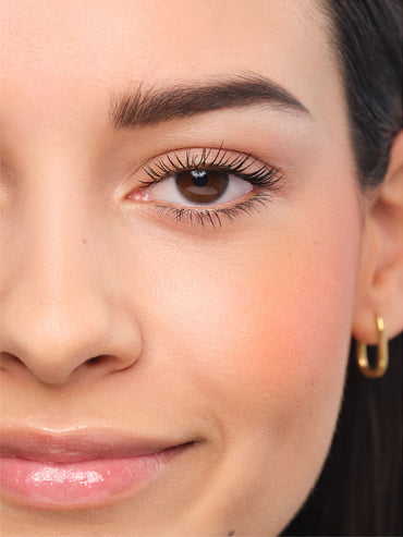 Made-up face with natural eyebrows.