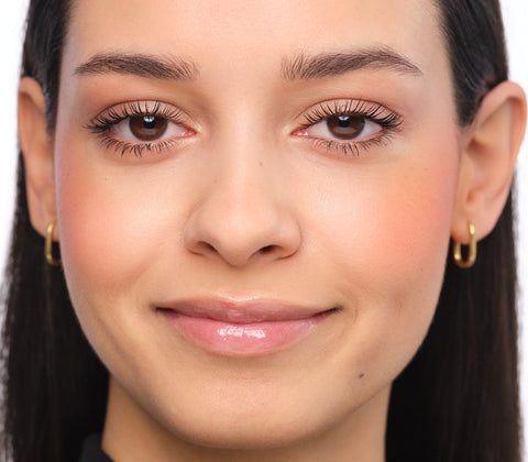 Smiling woman with natural, unstyled brows – the “before” look of the tutorial.