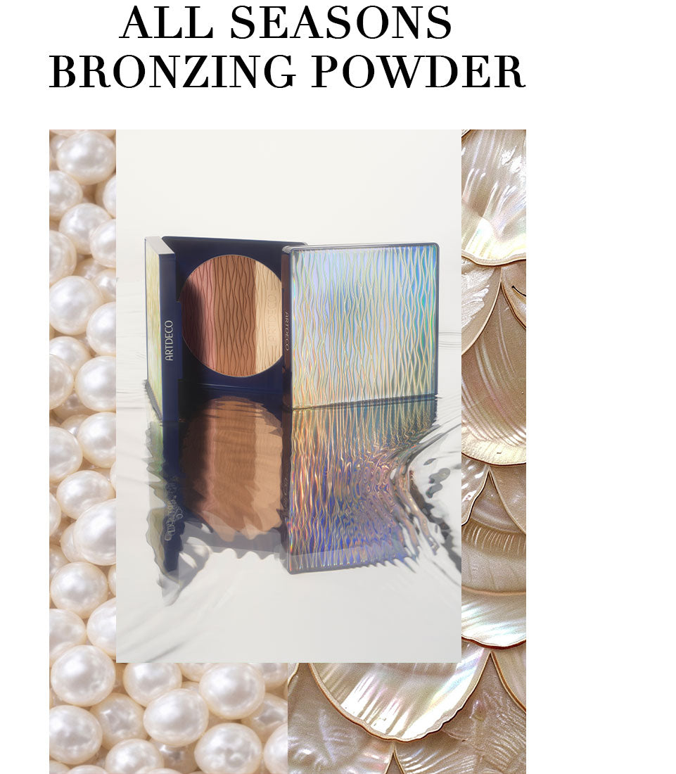 Product shot of a partially opened All Seasons Bronzing Powder resting on a surface reflecting water. "All Seasons Bronzing Powder" is written on the top in capital letters.