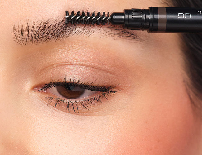 Eyebrows are combed with the brush from the Sculpting Brow Styler.
