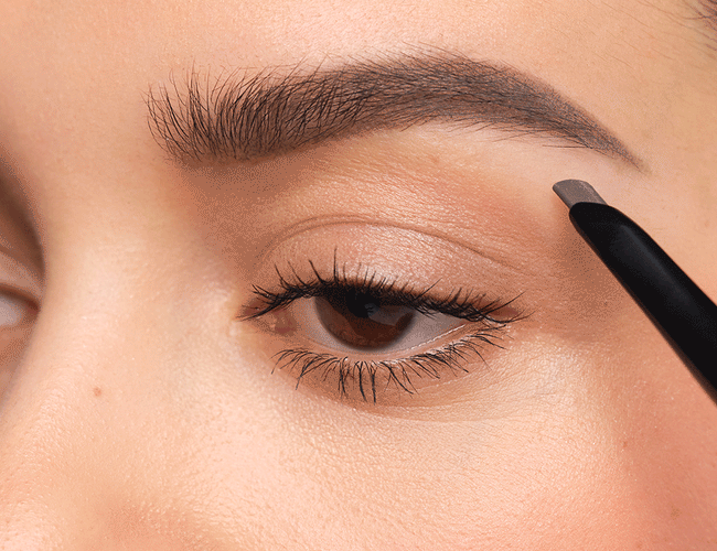 Graphic white lines show how eyebrows should be filled in with the Sculpting Brow Styler. First trace the arch, then the highest point and finally the front part of the eyebrow.