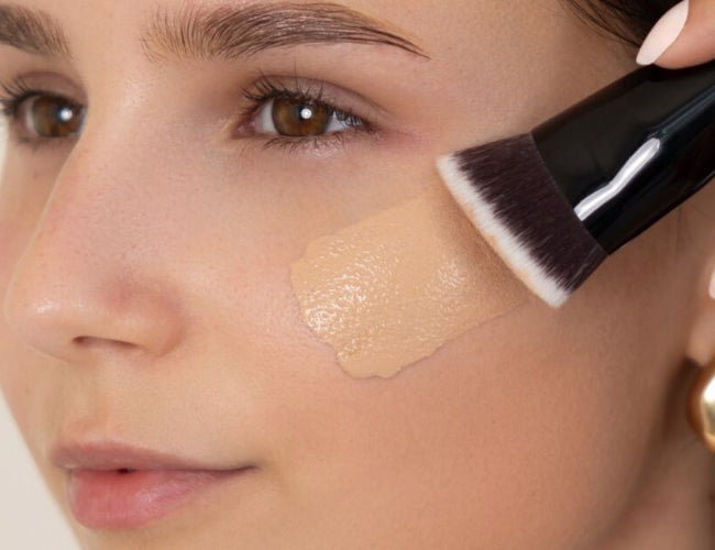 Model applies a liquid foundation for latte makeup.