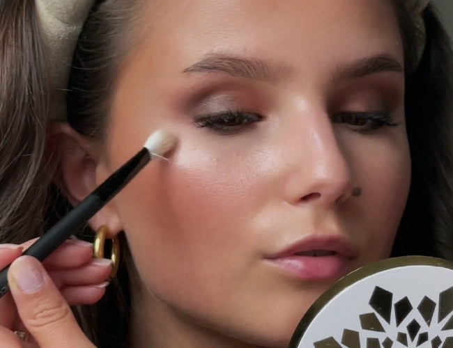 Model uses highlighter to create bright, delicate accents on her cheekbones.