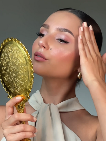 Made-up model looks at herself in a mirror.