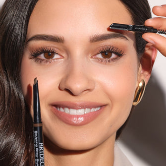 The model holds the ARTDECO Sculpting Brow Styler to her face and shows the different ends of the pencil: lead, brush and eyebrow razor.