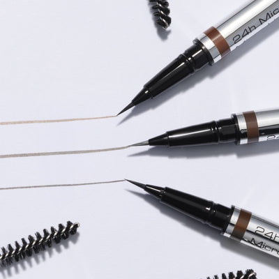 Three Ultra Fine Brow Liner colors without a cap on a brown background.
