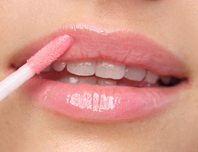 Close-up of the model’s lips, to which the Plumping Lip Fluid N°16 in “Gleaming Rose” has been applied