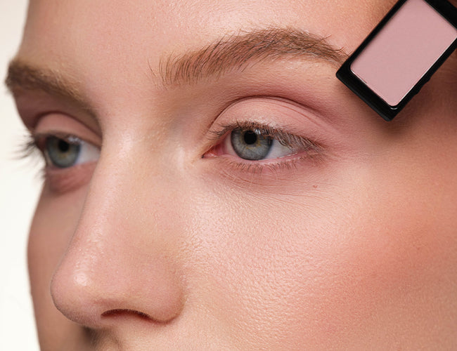 Close-up of the model’s eye, on which a light mauve eyeshadow is being used as a transition shade for the following eyeshadows