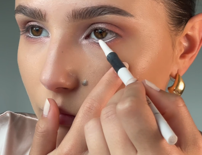 A white eyeliner is applied to the lower waterline.